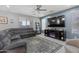Spacious living room with a comfortable sectional sofa, a ceiling fan, and a modern entertainment center at 18649 W Williams St, Goodyear, AZ 85338