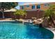 Picturesque pool with a rock waterfall, lush landscaping, and cool, refreshing water at 18649 W Williams St, Goodyear, AZ 85338