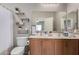 Bright bathroom featuring a double sink vanity, tile accents, and open shelving, offering ample storage at 19342 W Morning Glory Dr, Buckeye, AZ 85326