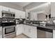 Galley kitchen showcasing stainless steel appliances and dark countertops at 19342 W Morning Glory Dr, Buckeye, AZ 85326