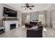 Cozy living room featuring a fireplace, media center, and large windows at 19342 W Morning Glory Dr, Buckeye, AZ 85326
