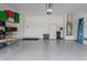 Spacious garage with epoxy floor, storage shelves, white refrigerator, and water heater at 1951 W Plum Rd, Phoenix, AZ 85085