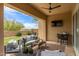 Inviting covered patio with comfortable seating, ceiling fan, and outdoor TV overlooking the backyard at 1951 W Plum Rd, Phoenix, AZ 85085