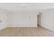 Minimalist living room with wood floors, ceiling fan, and a door leading to other parts of the house at 2022 N 61St Ave, Phoenix, AZ 85035