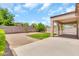 Spacious backyard with a covered patio, gravel, grass, and block fence at 209 E Diamond Trl, San Tan Valley, AZ 85143