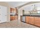 Bright kitchen with beautiful tile floors, stainless steel dishwasher and wooden cabinets at 209 E Diamond Trl, San Tan Valley, AZ 85143