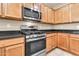Close-up of the kitchen featuring stainless steel appliances including oven, microwave and wooden cabinets at 209 E Diamond Trl, San Tan Valley, AZ 85143