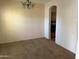 Empty dining room space featuring plush carpet, a chandelier, and access to an adjacent room at 21183 W Main St, Buckeye, AZ 85396