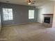Comfortable living room with a cozy fireplace, ceiling fan, and large windows at 21183 W Main St, Buckeye, AZ 85396