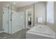 Bright bathroom featuring a glass shower, soaking tub, and white tile details at 22255 E Quintero Rd, Queen Creek, AZ 85142