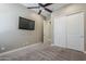 This bedroom features cozy carpet, a mounted TV, neutral walls, and a convenient closet space for comfortable living at 22255 E Quintero Rd, Queen Creek, AZ 85142