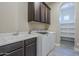 Functional laundry room features built-in cabinets, a utility sink, and modern machines for household efficiency at 22255 E Quintero Rd, Queen Creek, AZ 85142