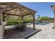 Covered outdoor dining area with a built-in grill and a view of the pool at 22255 E Quintero Rd, Queen Creek, AZ 85142
