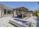 Outdoor kitchen and dining area with a built-in grill, fire pit, and covered patio at 22255 E Quintero Rd, Queen Creek, AZ 85142