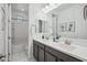 Bright bathroom featuring a double sink vanity, framed art and tub with shower at 22341 N 100Th Ln, Peoria, AZ 85383
