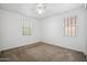 Bedroom featuring carpet, two bright windows, and a ceiling fan at 22341 N 100Th Ln, Peoria, AZ 85383