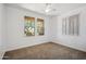 Bedroom featuring carpet, two bright windows, and a ceiling fan at 22341 N 100Th Ln, Peoria, AZ 85383