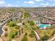 Aerial view showcasing a neighborhood park with lush landscaping, community pool, and playground at 22341 N 100Th Ln, Peoria, AZ 85383