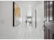 Inviting hallway with white tile flooring and modern art leading to an open dining area at 22341 N 100Th Ln, Peoria, AZ 85383