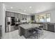 Contemporary kitchen featuring gray cabinets, stainless steel appliances, and a large island with bar seating at 22341 N 100Th Ln, Peoria, AZ 85383