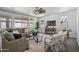 Cozy living room with a sectional sofa, large windows, a ceiling fan, and a decorative rug at 22341 N 100Th Ln, Peoria, AZ 85383