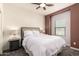 Inviting bedroom with a queen bed, lamps on nightstands, and a window with blinds for privacy at 2256 W Laurie Ln, Phoenix, AZ 85021