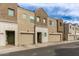 View of modern townhome exteriors with tan and brown color scheme and attached garages at 2256 W Laurie Ln, Phoenix, AZ 85021