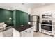 Open kitchen with stainless steel appliances, granite countertops, white cabinetry, and a functional island with barstools at 2256 W Laurie Ln, Phoenix, AZ 85021