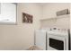 Functional laundry room featuring a washer, dryer, and a shelf above appliances at 2256 W Laurie Ln, Phoenix, AZ 85021