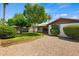 Beautiful backyard featuring a well-maintained lawn, gravel, and mature trees, creating a private outdoor oasis at 2264 S Don Carlos --, Mesa, AZ 85202