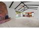 Spacious living room with brick fireplace, wood beam ceiling, and kitchen view at 2264 S Don Carlos --, Mesa, AZ 85202