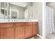 Bright bathroom featuring wooden cabinetry, a large mirror, and a shower with a patterned curtain at 3554 N Hooper St, Buckeye, AZ 85396