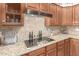 Kitchen featuring granite countertops, wooden cabinets, stainless steel appliances, and ceramic tile flooring at 3554 N Hooper St, Buckeye, AZ 85396