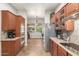 Kitchen with wooden cabinets, stainless steel appliances, and a view of the adjacent sitting area at 3554 N Hooper St, Buckeye, AZ 85396
