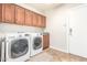 Functional laundry room with modern washer and dryer units and ample cabinet space at 3554 N Hooper St, Buckeye, AZ 85396