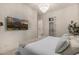 Bright bedroom with hardwood floors, white walls, a flat screen TV, and en suite bathroom entrance at 3684 E Boot Track Trl, Gilbert, AZ 85296