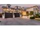 Dusk view of the exterior showcasing garage doors, a welcoming entrance, and manicured hedges at 3684 E Boot Track Trl, Gilbert, AZ 85296