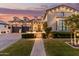 Inviting front exterior featuring manicured landscaping, brick walkway, and a charming facade at sunset at 3684 E Boot Track Trl, Gilbert, AZ 85296