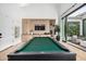 Bright game room with custom built-ins and modern pool table, seamlessly connected to an outdoor patio at 3684 E Boot Track Trl, Gilbert, AZ 85296