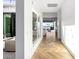 Bright hallway showcasing herringbone wood floors, leading to an outdoor patio and adjacent living space at 3684 E Boot Track Trl, Gilbert, AZ 85296