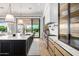 Modern kitchen features stylish island, light wood cabinetry and access to the serene backyard and outdoor living spaces at 3684 E Boot Track Trl, Gilbert, AZ 85296