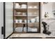 Close up of modern kitchen cabinet with ribbed glass doors, light wood shelves, and marble countertops at 3684 E Boot Track Trl, Gilbert, AZ 85296