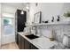 Chic kitchen featuring marble countertop, modern sink, dark cabinets, and brass fixtures at 3684 E Boot Track Trl, Gilbert, AZ 85296