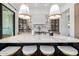 Large kitchen island with a white marble top, comfortable seating, and designer pendant lighting overhead at 3684 E Boot Track Trl, Gilbert, AZ 85296