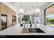 Gourmet kitchen island with marble countertop, stainless steel sink, and elegant pendant lighting, perfect for meal preparation at 3684 E Boot Track Trl, Gilbert, AZ 85296