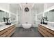 Luxury main bathroom featuring dual vanities, dual walk-in glass showers, and a stylish soaking tub at 3684 E Boot Track Trl, Gilbert, AZ 85296