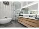 Elegant main bathroom with soaking tub, glass enclosed shower, marble countertop, and wooden cabinets at 3684 E Boot Track Trl, Gilbert, AZ 85296