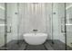 Modern bathroom featuring dual walk-in showers, a luxurious soaking tub, and sleek grey tile flooring at 3684 E Boot Track Trl, Gilbert, AZ 85296