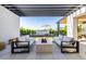 Modern outdoor seating area with fire pit overlooking a manicured lawn and water feature, perfect for relaxation and entertainment at 3684 E Boot Track Trl, Gilbert, AZ 85296