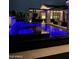 The modern backyard showcases a luxurious pool with ambient blue lighting and a covered patio for ultimate outdoor relaxation at 3684 E Boot Track Trl, Gilbert, AZ 85296